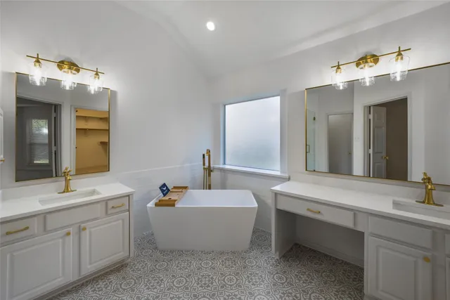 a bathroom with a double vanity sink mirror and bathtub