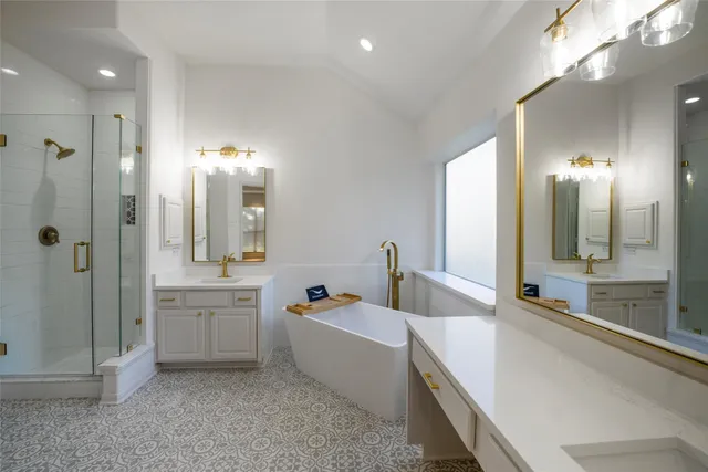 a large spacious bathroom with a tub sink shower and mirror