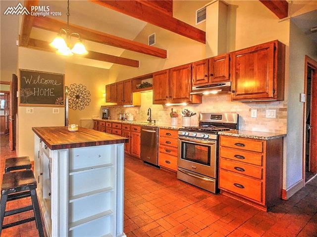 10380 Link Road Fountain, CO 80817 - Photo 5 of 35 Large and spacious kitchen with granite countertops, tile backsplash, stainless steel appliances and eating bar. The kitchen is open to the greatroom and access to the screened in porch.