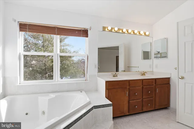 a bathroom with a tub a sink and a window