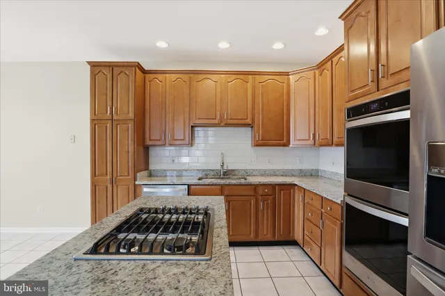 a kitchen with kitchen island granite countertop stainless steel appliances and cabinets