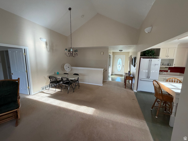 10000 North 6730th East Spring City, UT 84662 - Photo 5 of 31 Vaulted ceiling great room featuring carpeted flooring, a decorative chandelier, and wall sconces