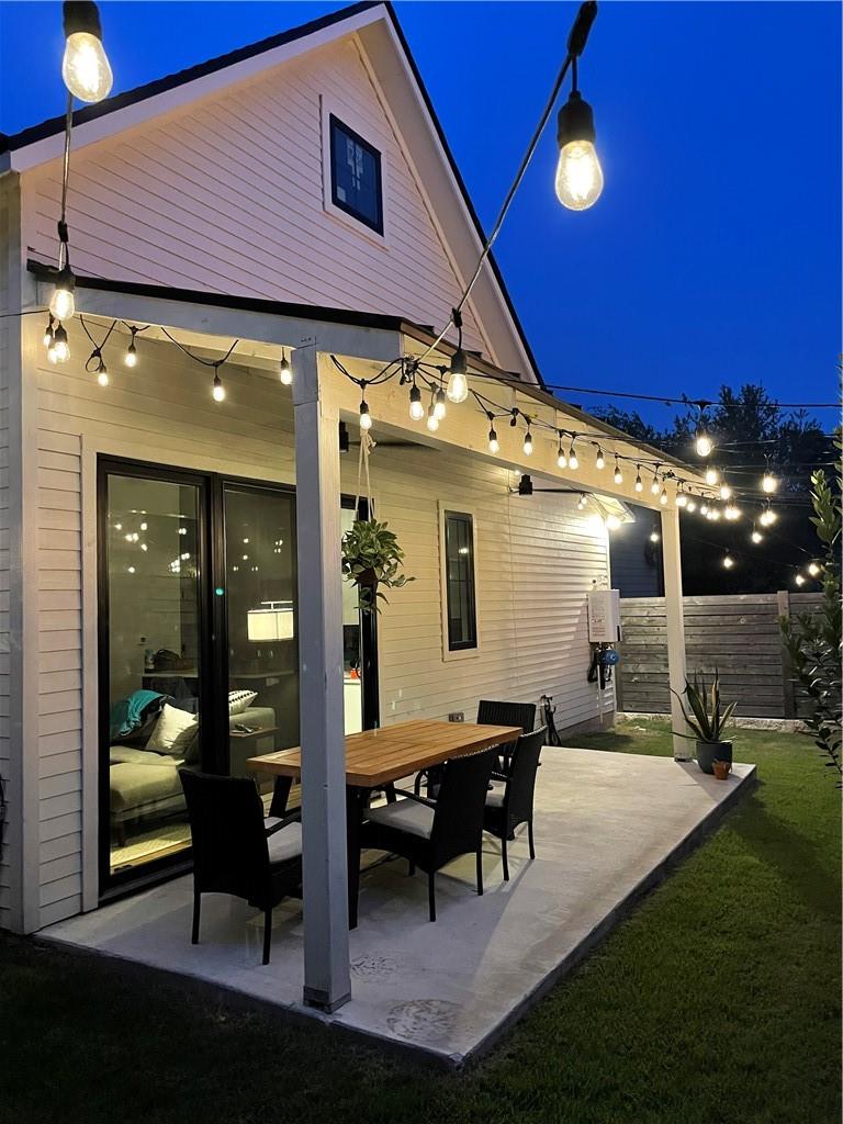 2002 East 9th Street, Unit 2 Austin, TX 78702 - Photo 24 of 32 An inviting outdoor living space features string lights and a dining area, perfect for twilight gatherings.
