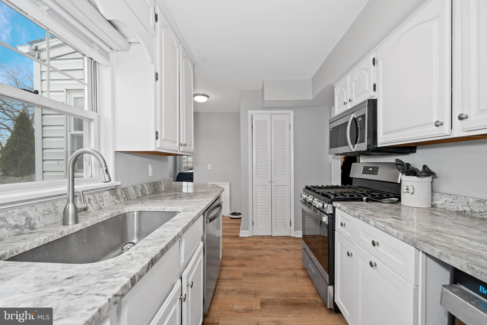 704 Harwood Road Wilmington, DE 19804 - Photo 11 of 30 a kitchen with stainless steel appliances granite countertop a sink stove and cabinets