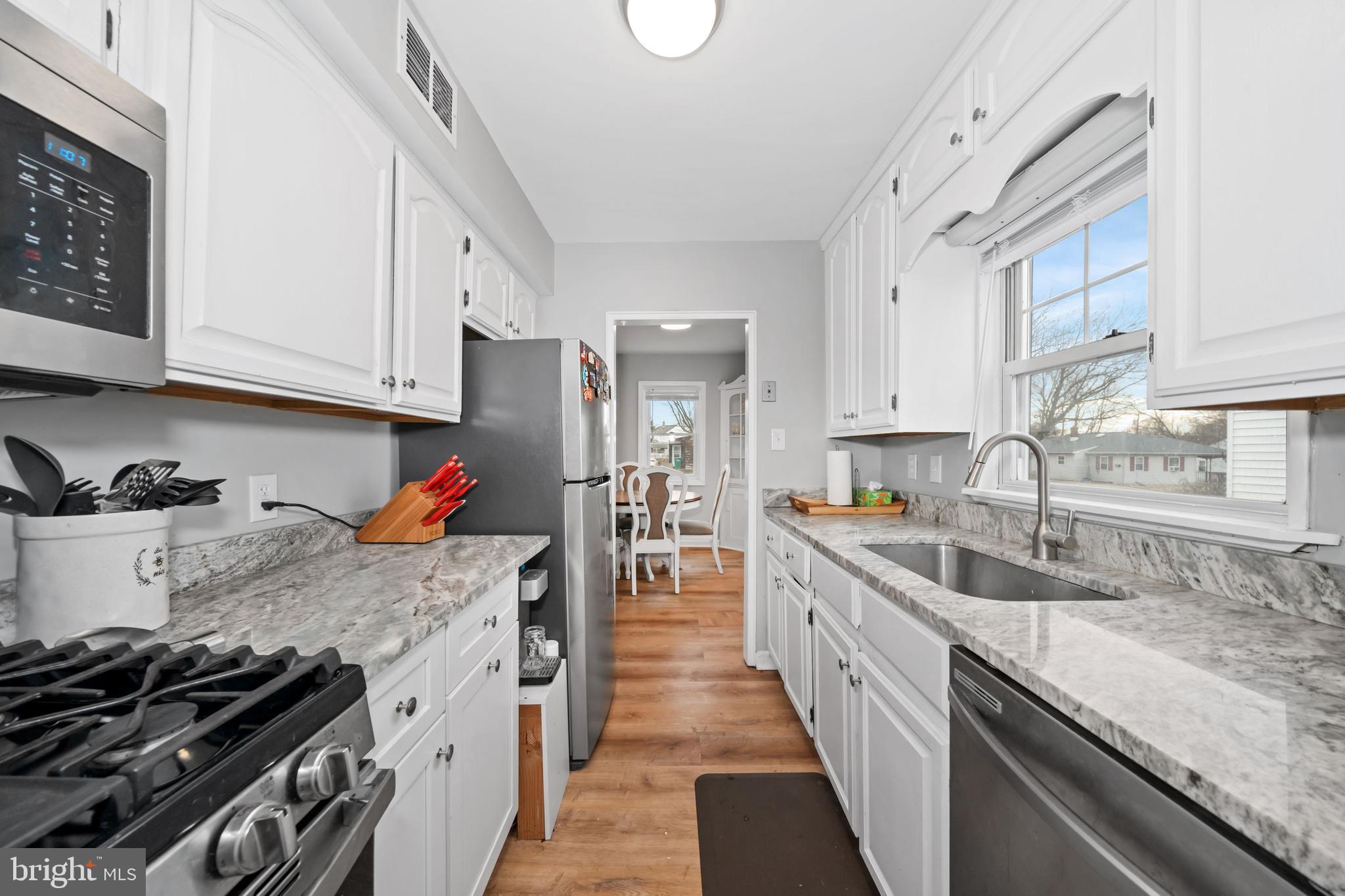 704 Harwood Road Wilmington, DE 19804 - Photo 9 of 30 a kitchen with granite countertop a stove sink and cabinets