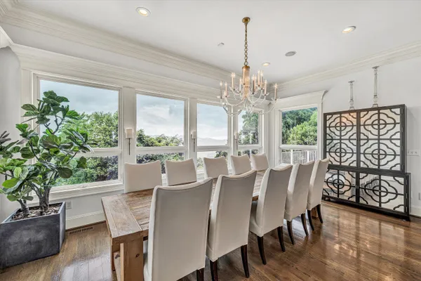 a living room with stainless steel appliances furniture wooden floor and a kitchen view