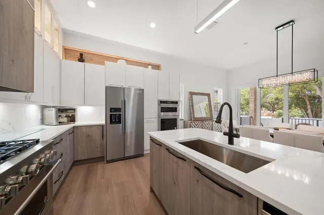 a kitchen with a sink stove top oven and refrigerator