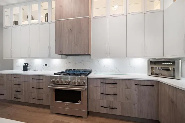 a kitchen with granite countertop white cabinets and stainless steel appliances