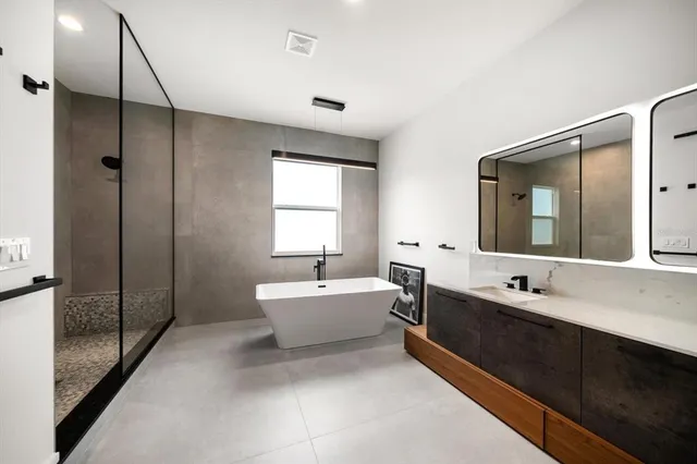 a spacious bathroom with a double vanity sink mirror and bathtub