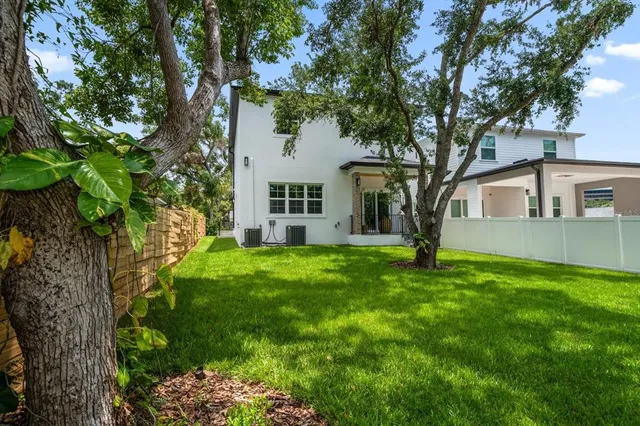 a view of a house with backyard and a tree
