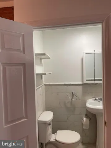 a white toilet sitting next to a bathroom sink
