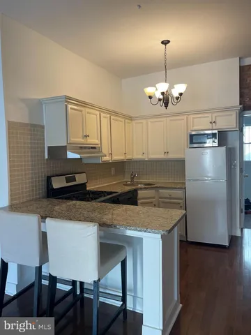 a kitchen with stainless steel appliances granite countertop a sink refrigerator and microwave