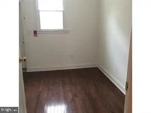 a view of a small space with wooden floor and a window