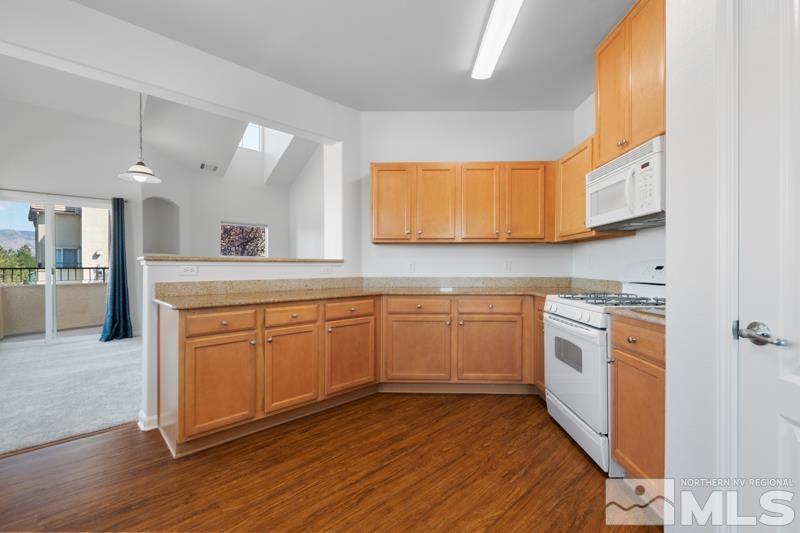 17000 Wedge Parkway, Unit 2925 Reno, NV 89511 - Photo 8 of 23 a kitchen with stainless steel appliances granite countertop wooden cabinets a sink a stove a dining table and chairs