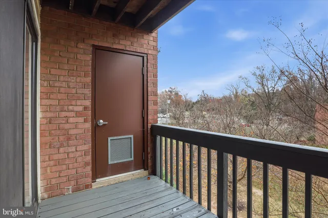 a view of a balcony with wooden floor and fence