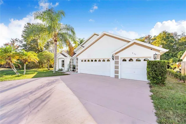 a view of a house with a yard and potted plants