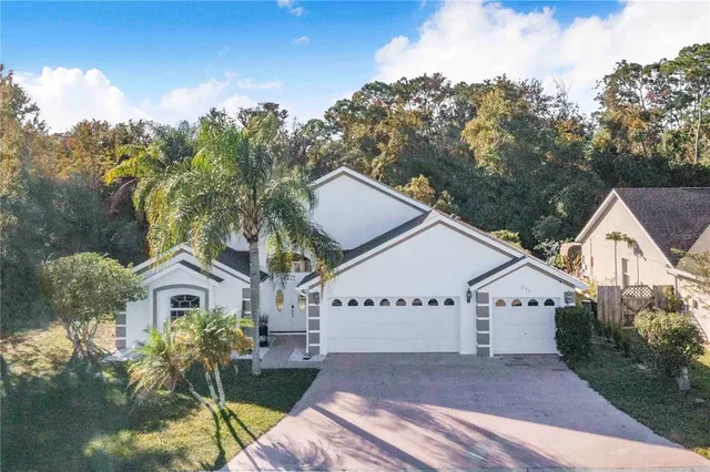 a view of house with garden and tall trees