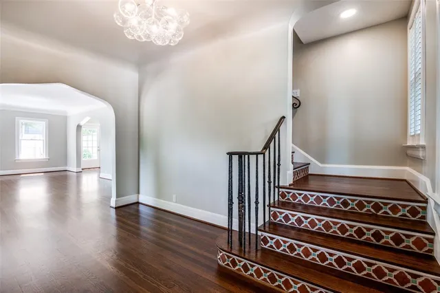 a view of a hallway with wooden floor and staircase