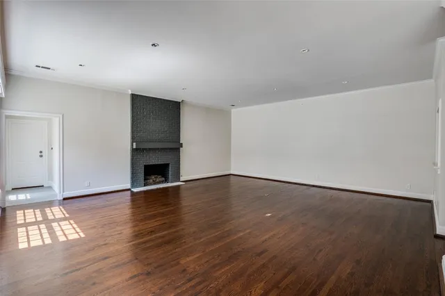 a view of empty room with wooden floor and fireplace