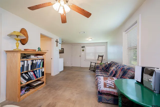 a living room with furniture and a book shelf