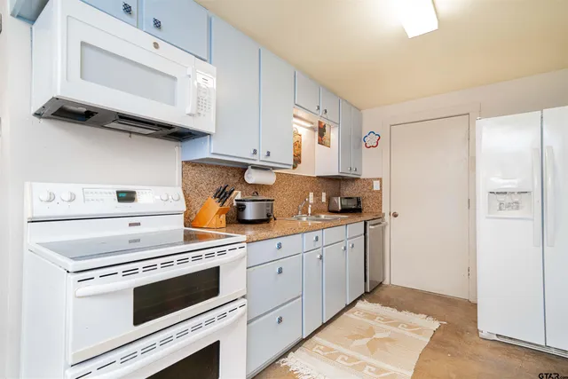 a kitchen with cabinets stainless steel appliances and a counter space