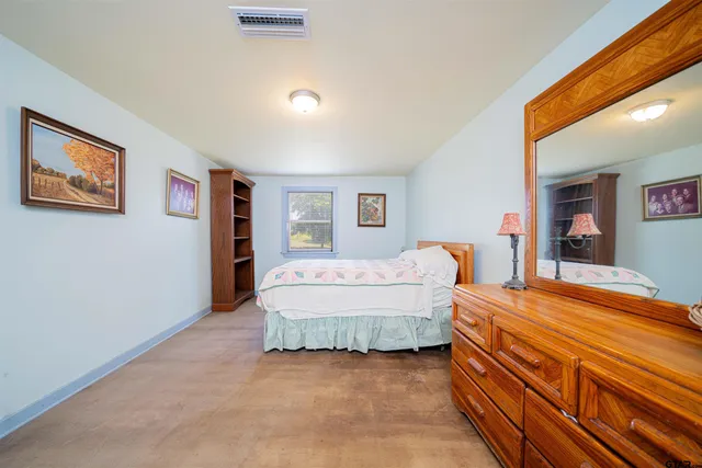 a bedroom with a large bed and a chandelier