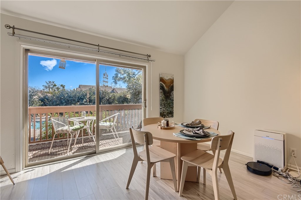 207 Orange Blossom, Unit 23 Irvine, CA 92618 - Photo 11 of 28 a dining room with furniture and a floor to ceiling window