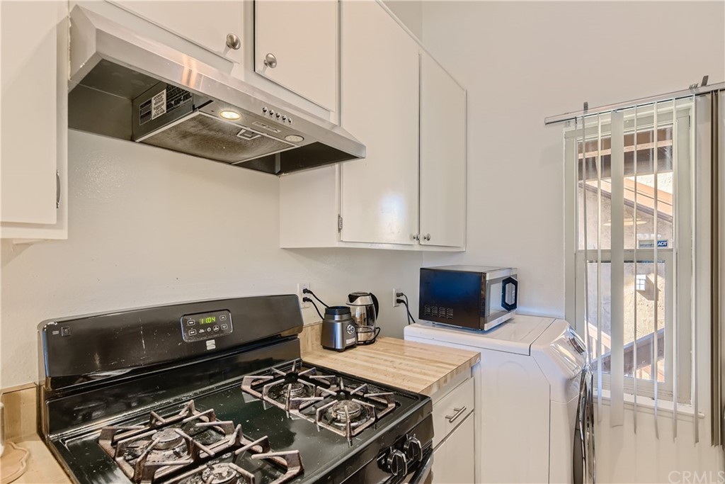 207 Orange Blossom, Unit 23 Irvine, CA 92618 - Photo 9 of 28 a kitchen with granite countertop a stove and a microwave