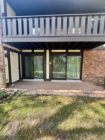 a view of a house with a deck and a small yard