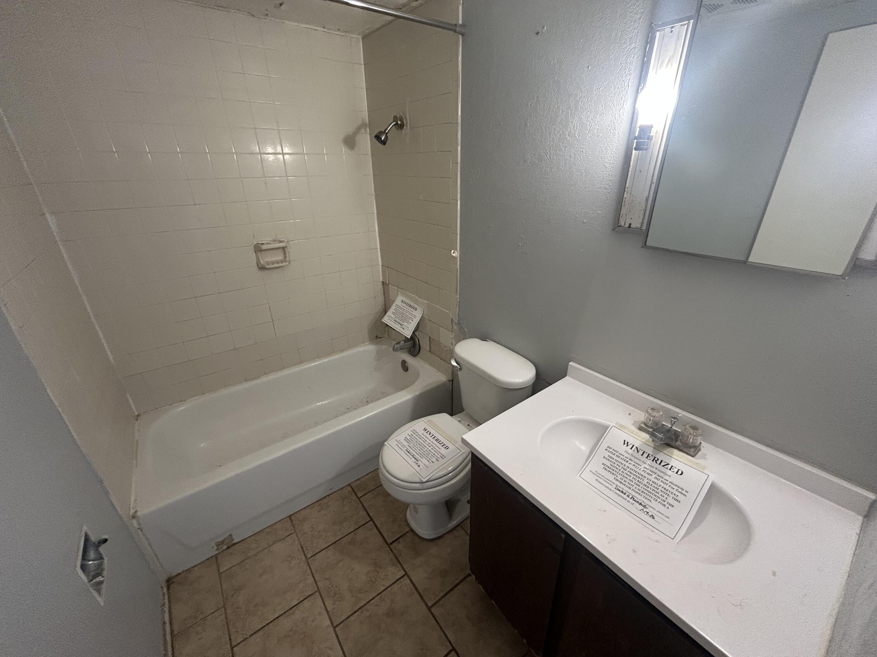 100 Pecos Place Plainview, TX 79072 - Photo 11 of 32 a bathroom with a sink a toilet and bathtub