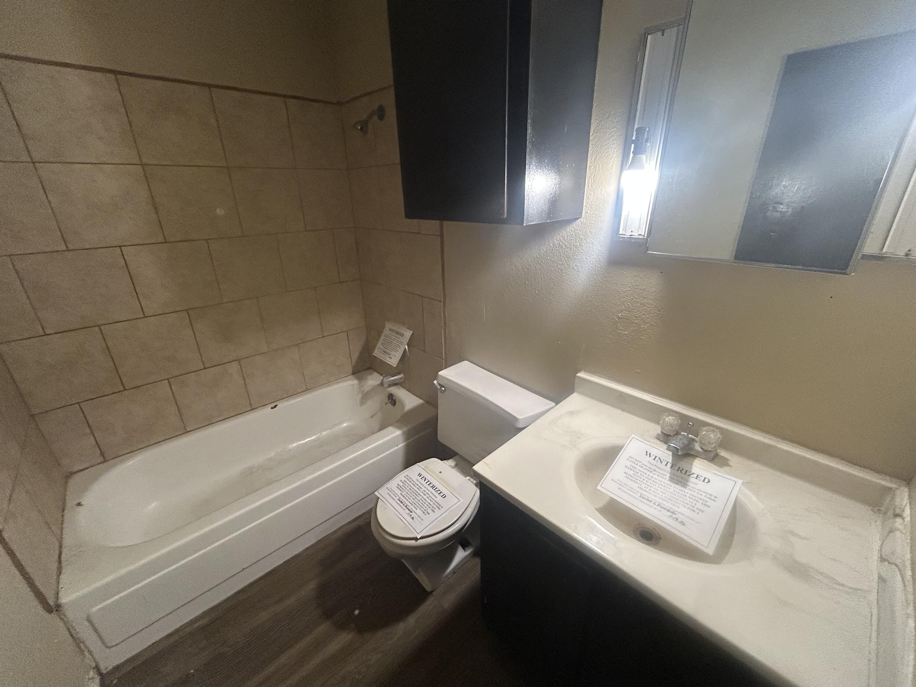 100 Pecos Place Plainview, TX 79072 - Photo 18 of 32 a bathroom with a sink a toilet and bathtub