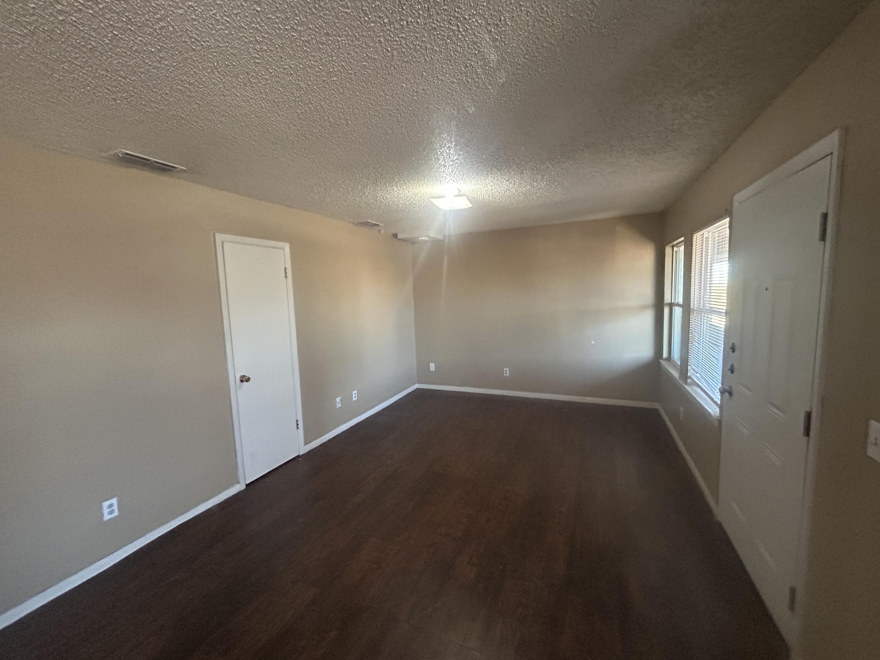 100 Pecos Place Plainview, TX 79072 - Photo 19 of 32 wooden floor in an empty room with a window