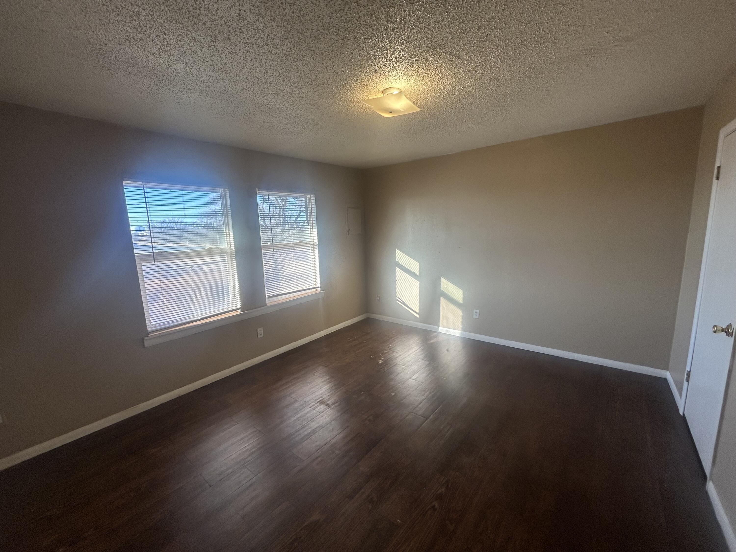 100 Pecos Place Plainview, TX 79072 - Photo 23 of 32 a view of an empty room with wooden floor and a window