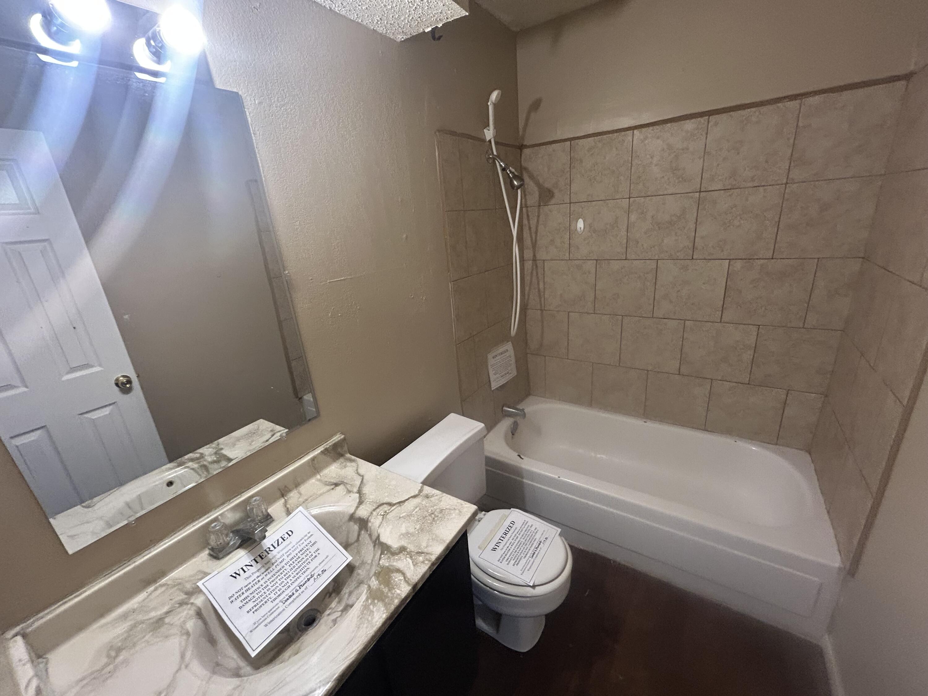 100 Pecos Place Plainview, TX 79072 - Photo 25 of 32 a bathroom with a sink a toilet and bathtub