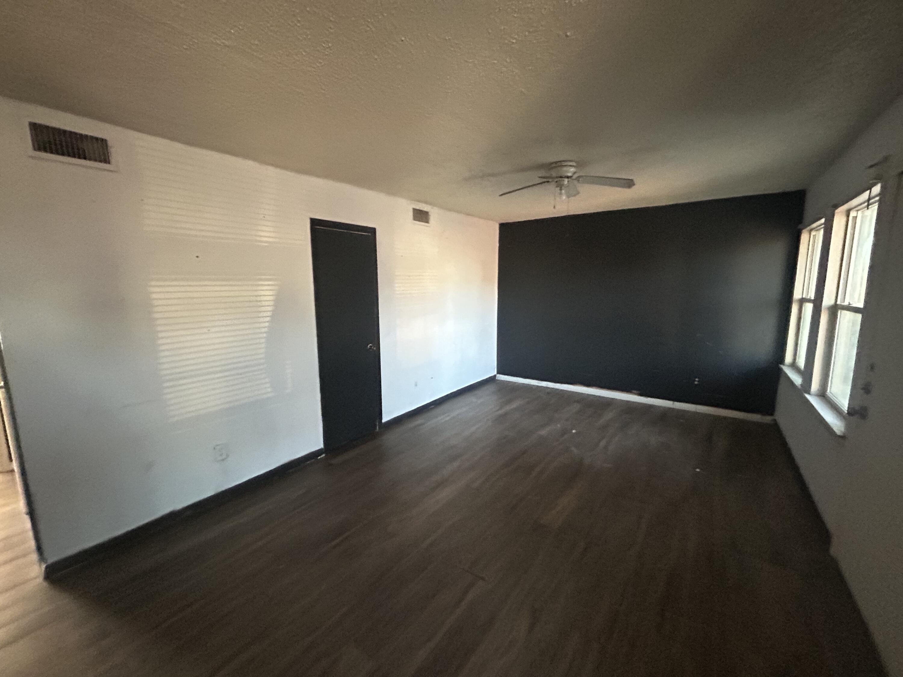 100 Pecos Place Plainview, TX 79072 - Photo 26 of 32 an empty room with wooden floor and windows