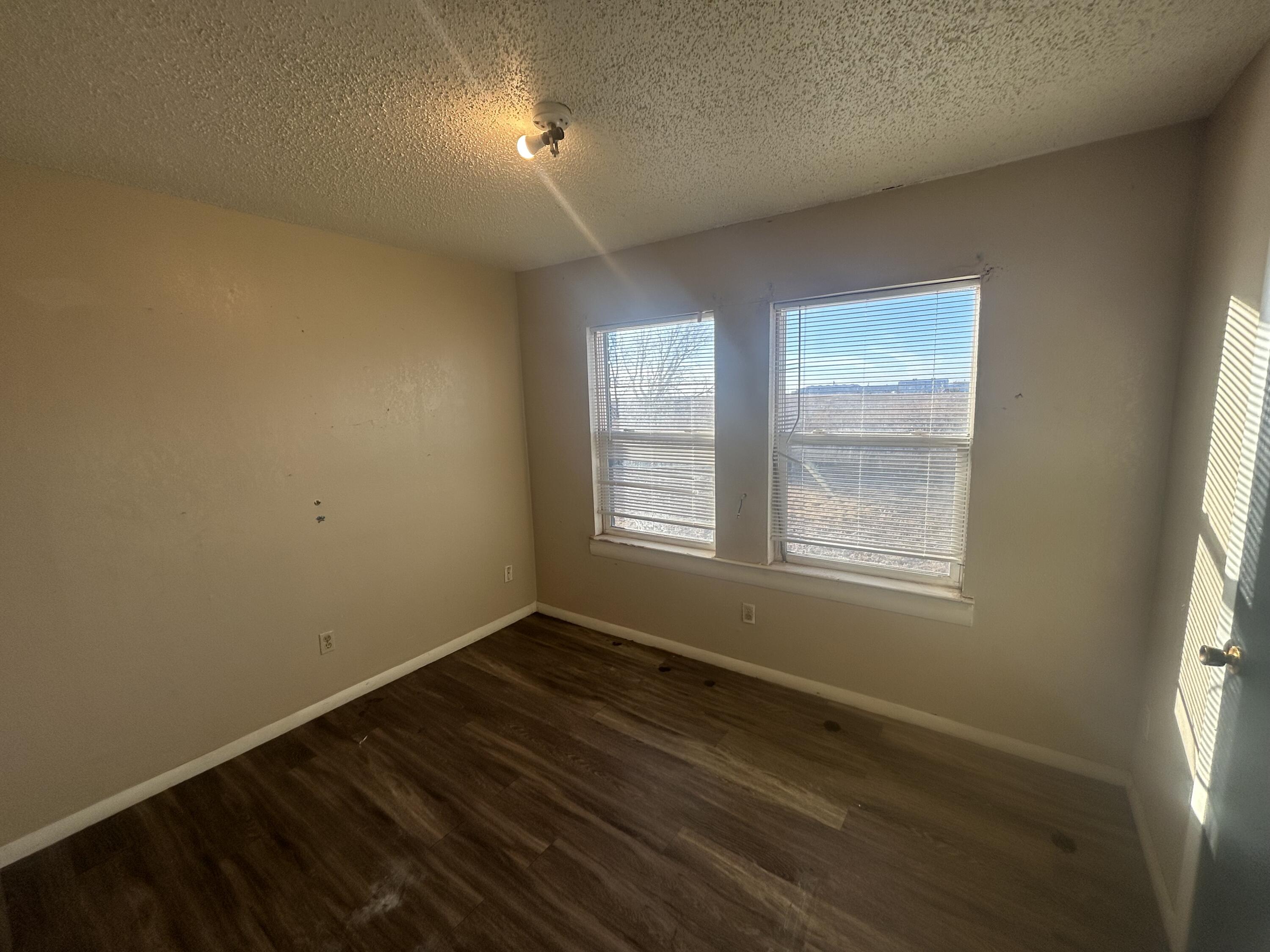100 Pecos Place Plainview, TX 79072 - Photo 31 of 32 an empty room with wooden floor and windows