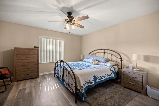 a bedroom with a bed a chandelier and dresser