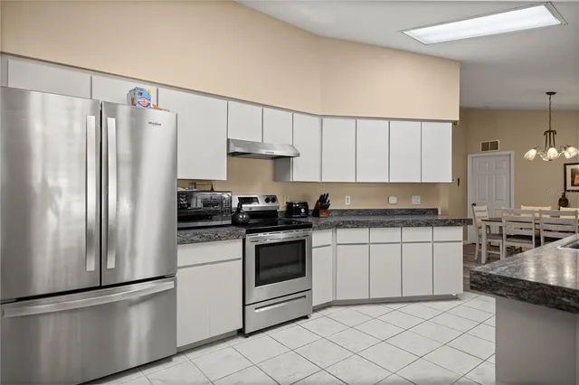 a kitchen with stainless steel appliances granite countertop a refrigerator sink and stove