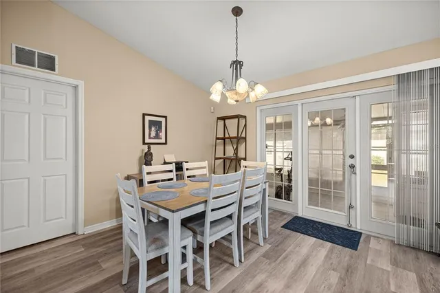 a view of a dining room with furniture wooden floor and chandelier