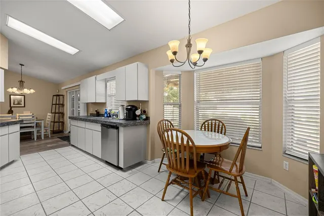 a kitchen with a dining table chairs cabinets and stainless steel appliances