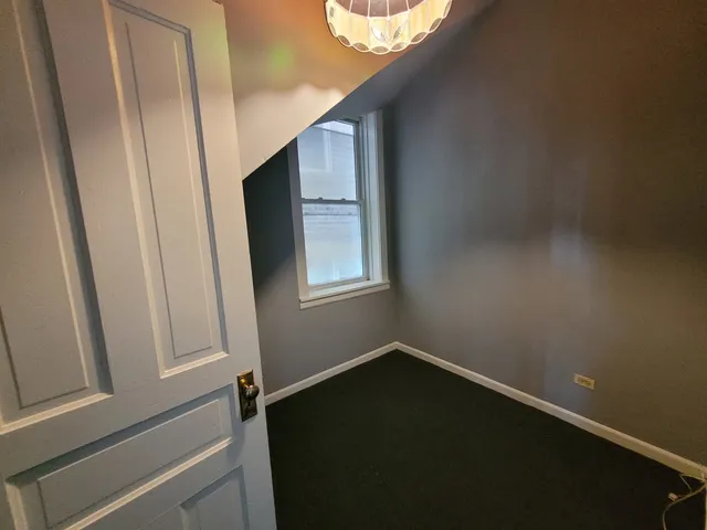 a view of a small space with wooden floor and a window