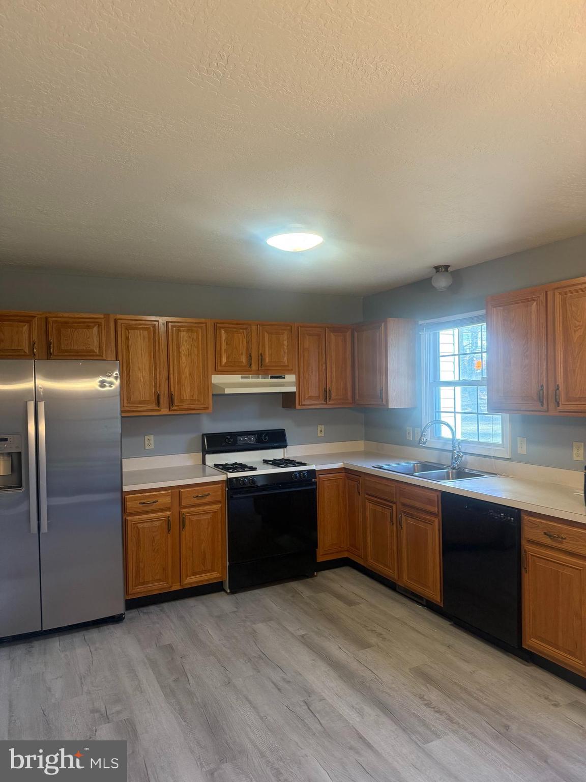 a large kitchen with wooden floors and stainless steel appliances