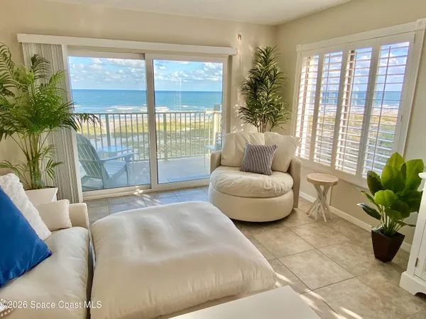 a living room with furniture and a floor to ceiling window