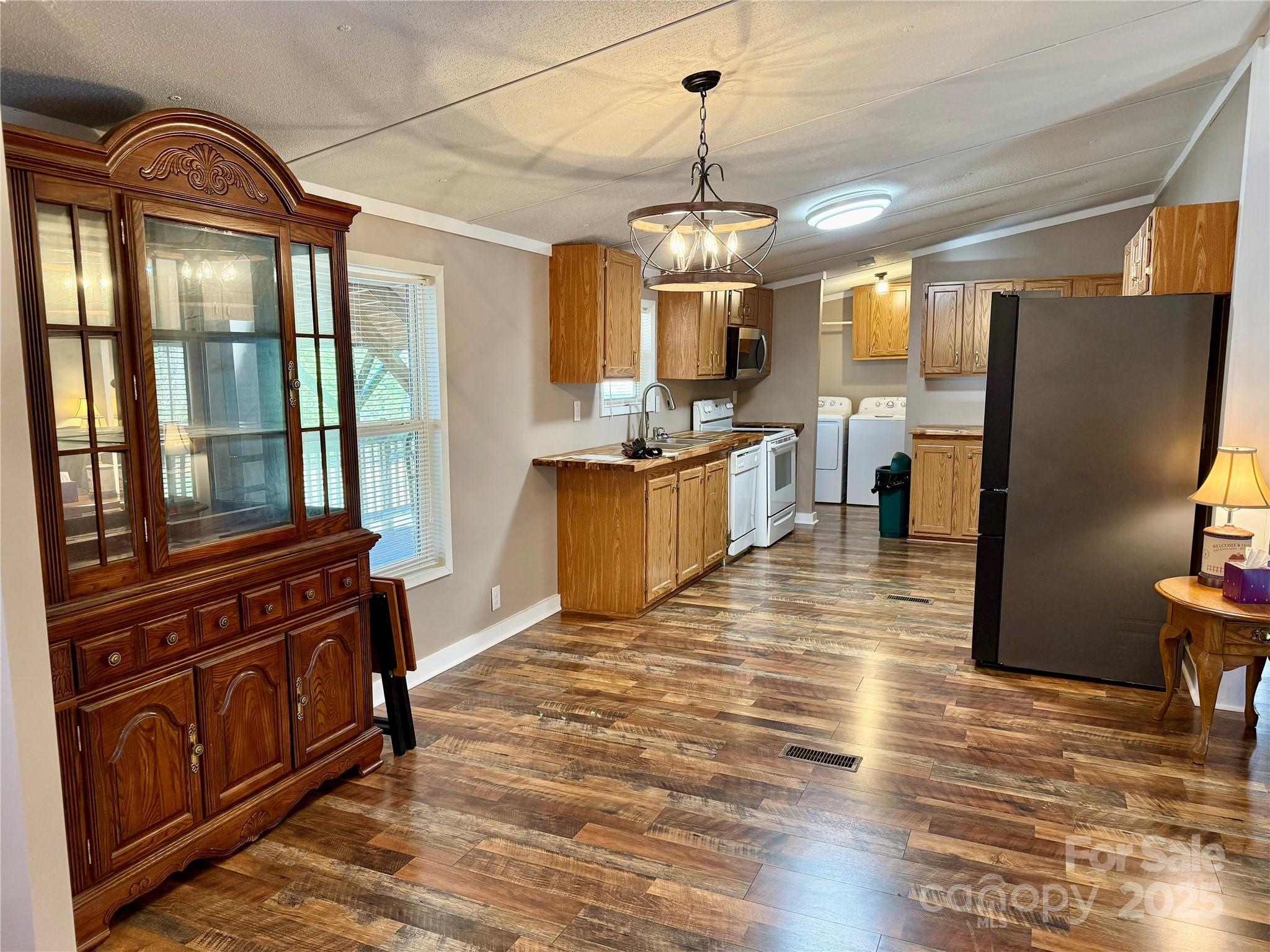 209 Romans Road China Grove, NC 28023 - Photo 9 of 25 a view of a kitchen with stainless steel appliances granite countertop a stove top oven a refrigerator a dining table and chairs with wooden floor