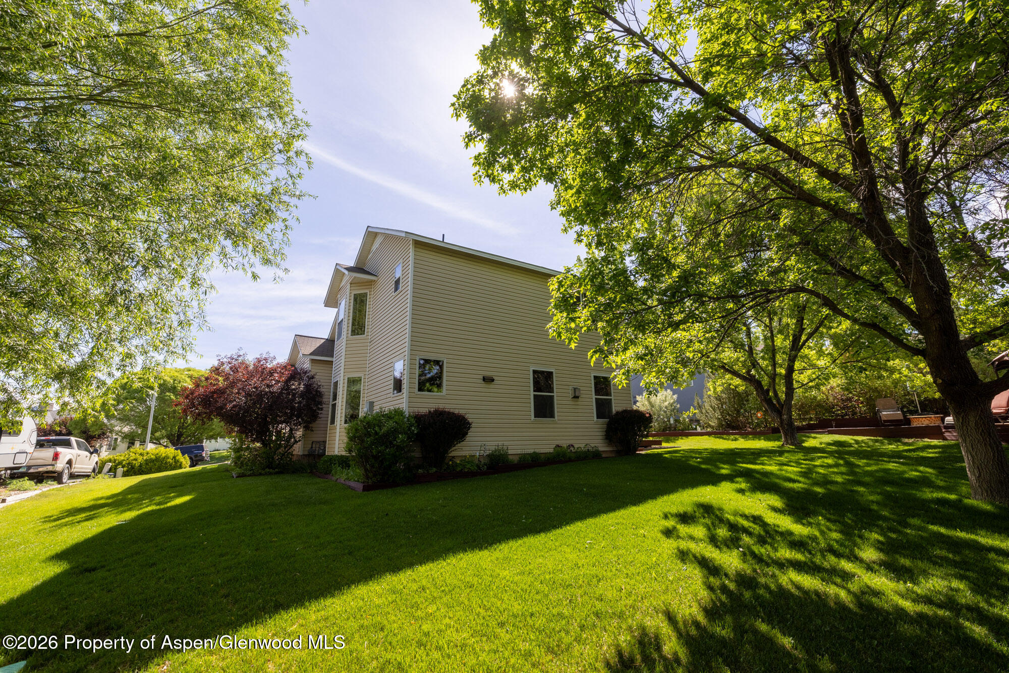 1335 Firethorn Drive Rifle, CO 81650 - Photo 25 of 30 a view of a white house with a big yard and large trees