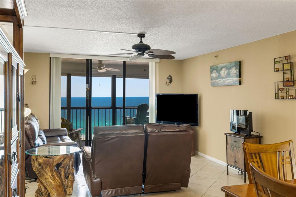 14900 Gulf Boulevard, Unit 410 Madeira Beach, FL 33708 - Photo 33 of 76 a living room with furniture a flat screen tv and floor to ceiling window
