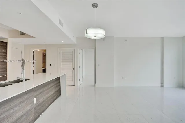 a view of kitchen with granite countertop cabinets and refrigerator