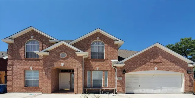 a front view of a house with plants