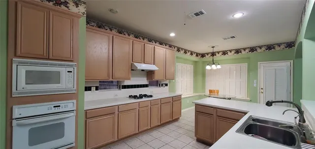 a kitchen with cabinets a sink stainless steel appliances and counter space