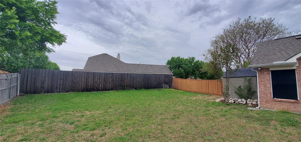 1003 Spring Tide Drive Wylie, TX 75098 - Photo 21 of 24 a view of a backyard with potted plants and wooden fence